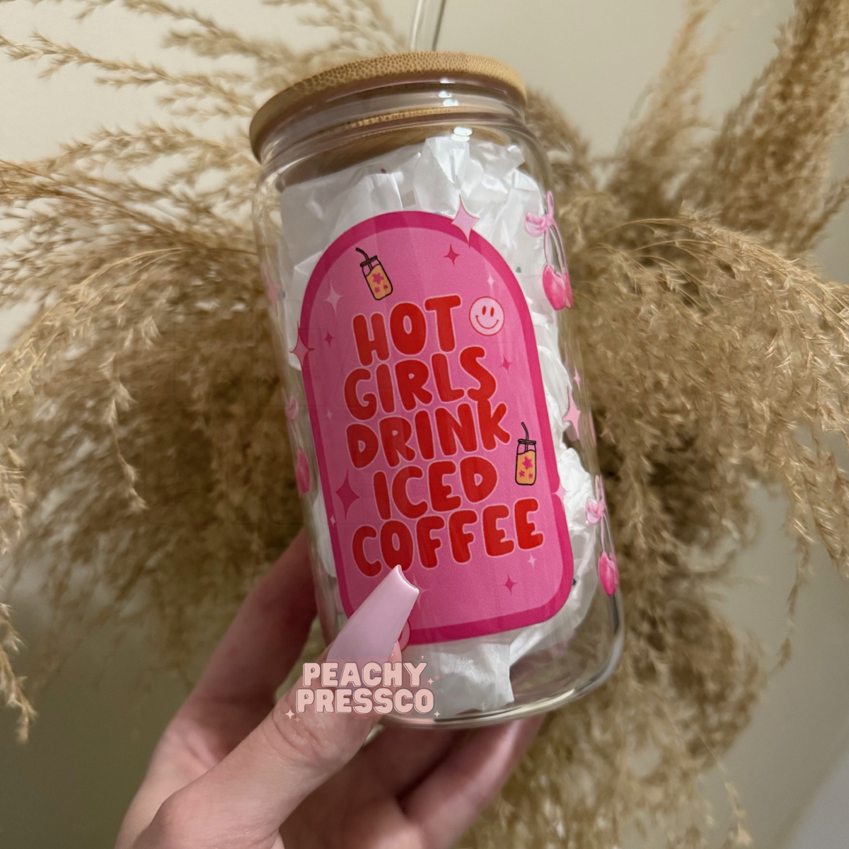 Cute glass cup featuring the phrase "Hot Girls Drink Iced Coffee" with pink cherries, smiley faces, sparkles, and a fun coquette-inspired design.