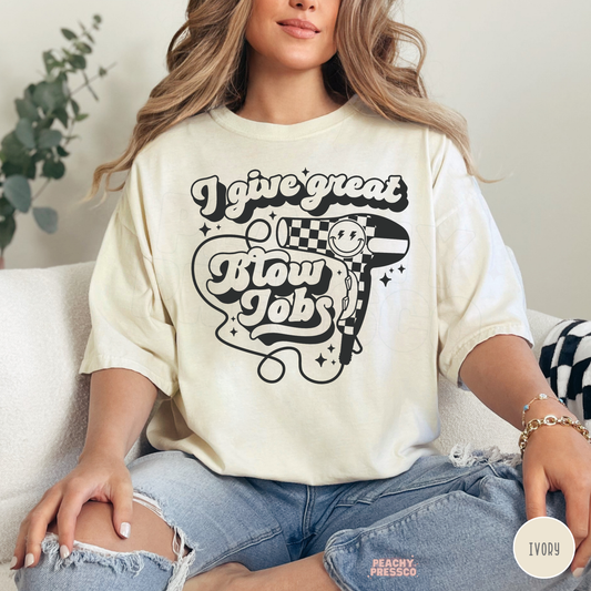 Woman wearing an ivory short sleeve T-shirt with I Give Great Blow Jobs retro typography, checkered hair dryer, smiley face and black star accents.