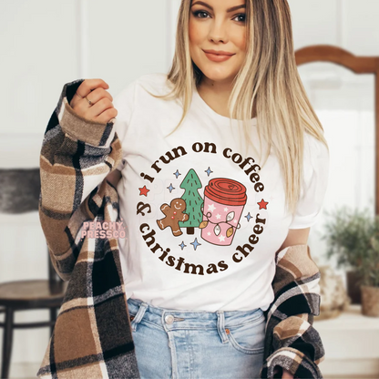 Women wearing a white "I Run On Coffee & Christmas Cheer" t-shirt styled under a brown plaid flannel shacket.
