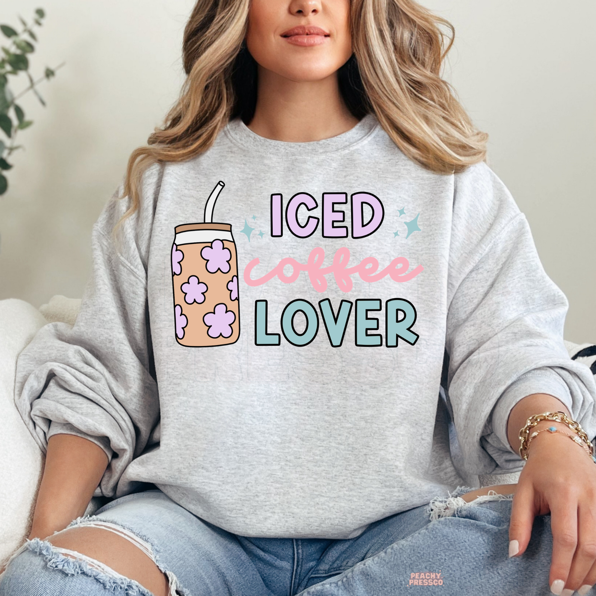Ash grey Iced Coffee Lover sweatshirt featuring a floral iced coffee cup, pastel pink script, lavender letters and teal lettering.