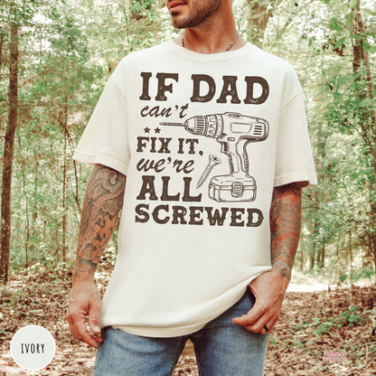 Ivory t-shirt with the funny "If Dad Can't Fix It, We're All Screwed" graphic featuring a cordless drill and screw. Perfect gift for dads who love tools, woodworking, repairs, and DIY projects.