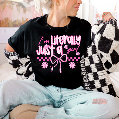 Woman wearing a black graphic t-shirt featuring the phrase "Literally Just a Girl" with pink coquette bow, checkered accents, and daisy flowers.