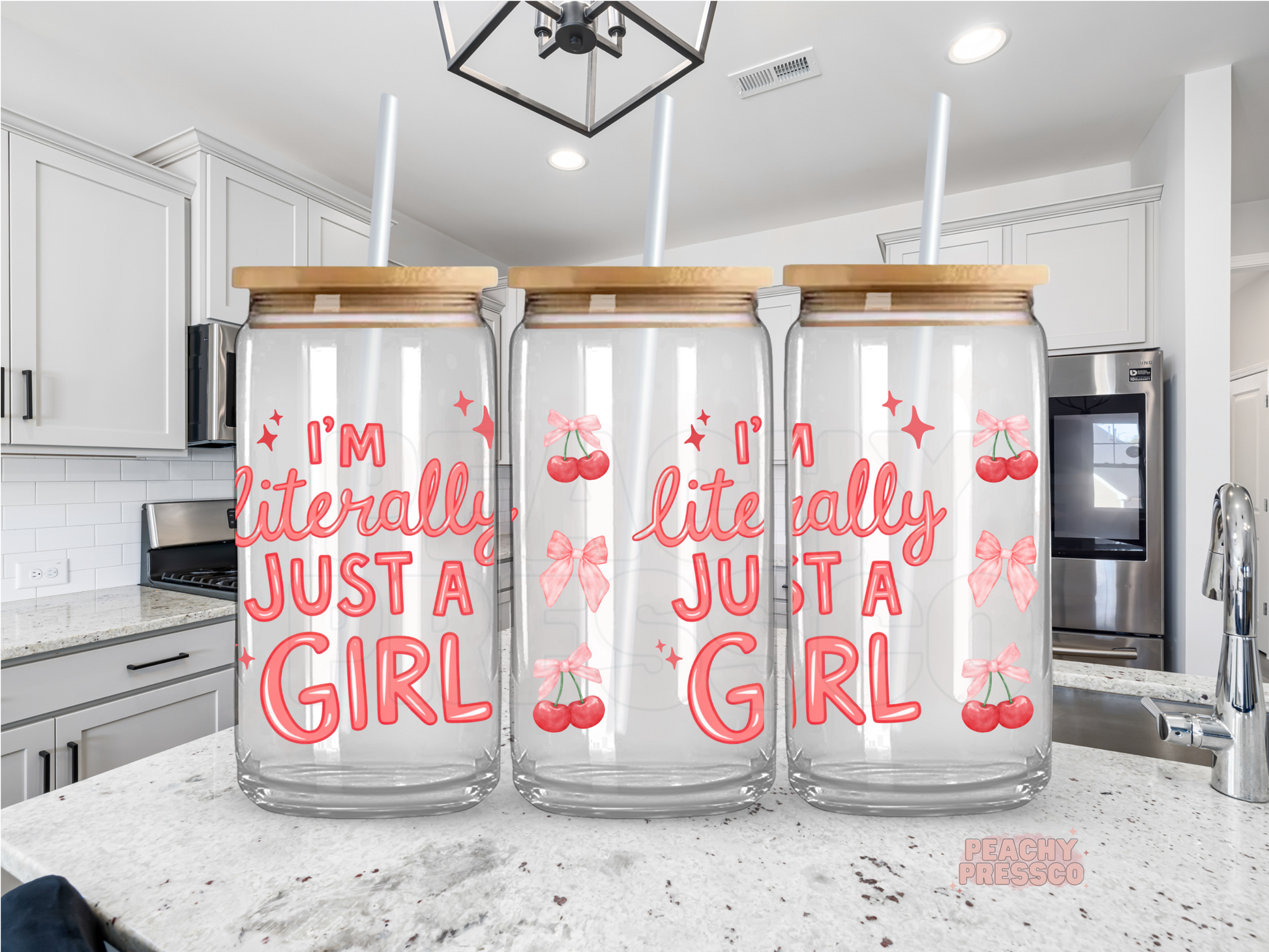 Clear glass cup with "I'm Literally Just a Girl" lettering decorated with pink cherries, bows, and sparkles for a fun coquette iced coffee aesthetic.