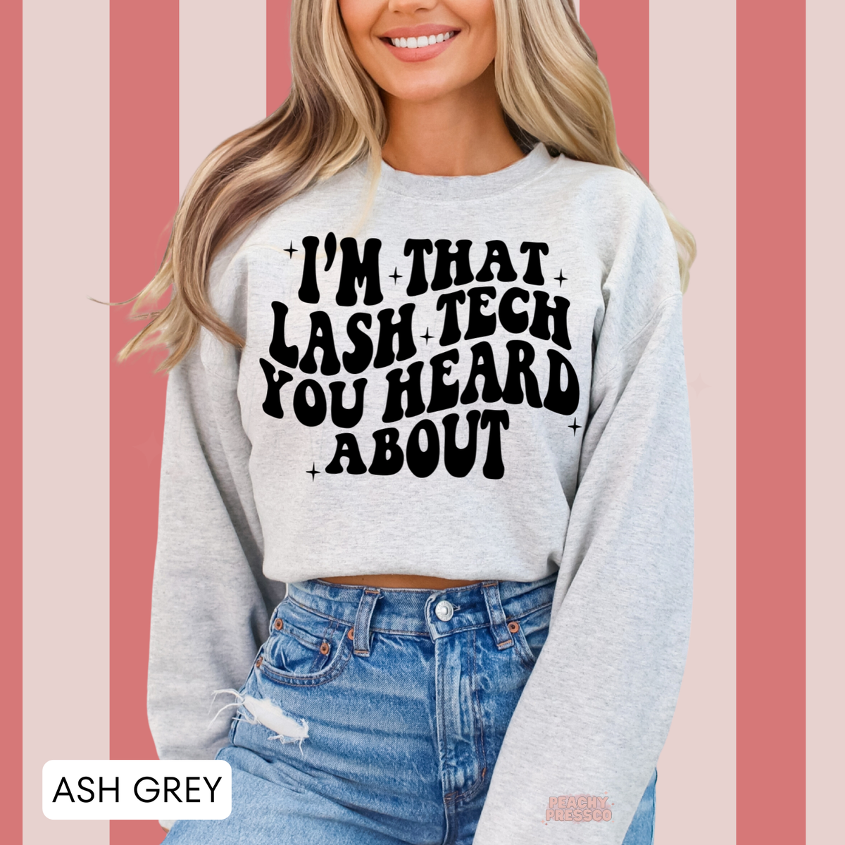 Woman modelling an ash grey lash tech crewneck sweatshirt with the black I'm That Lash Tech You Heard About graphic and small stars.
