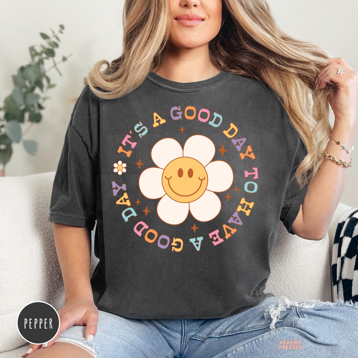Pepper Comfort Colors t-shirt with a happy smiley daisy surrounded by pastel retro text reading "It's a Good Day to Have a Good Day" for a positive everyday look.