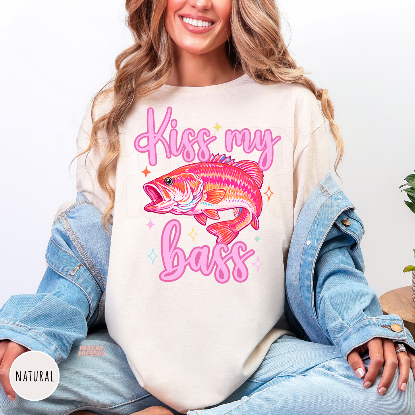 Natural unisex t-shirt featuring a vibrant pink bass fish with the funny phrase "Kiss My Bass." Cute fishing graphic tee perfect for lake days, bass fishing, and summer adventures.