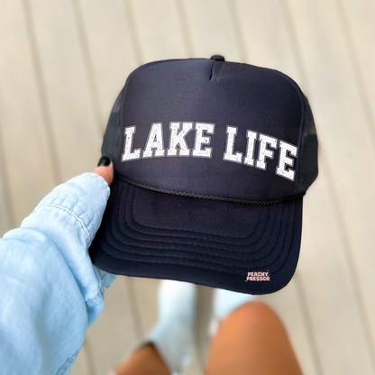 Black foam trucker hat with distressed "LAKE LIFE" varsity lettering, perfect for lake lovers, boating, cabin weekends, fishing trips, and everyday summer wear.