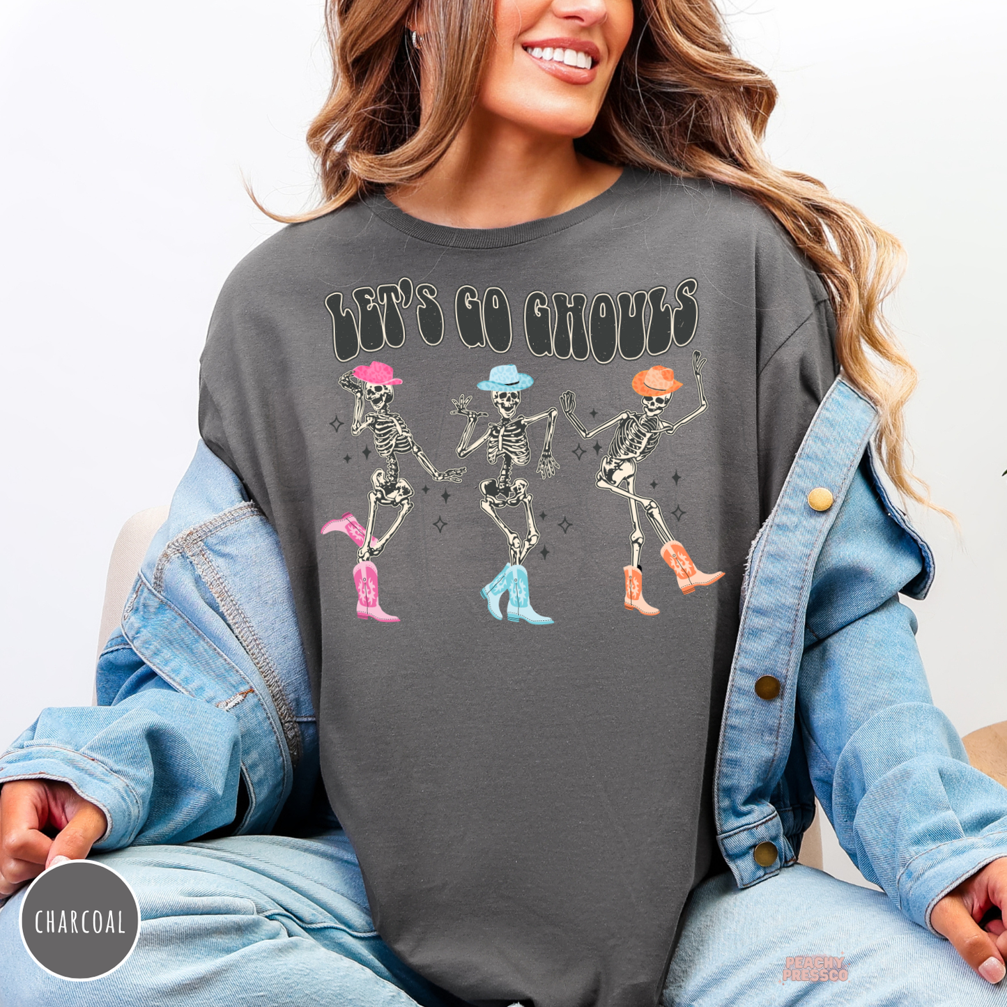 Charcoal Halloween T-shirt featuring Let’s Go Ghouls dancing skeleton cowgirls with colorful cowboy hats and boots