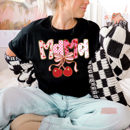 Woman wearing a black t-shirt with a cute Mama cherry bow design featuring pink cherry patterns and coquette-inspired artwork.