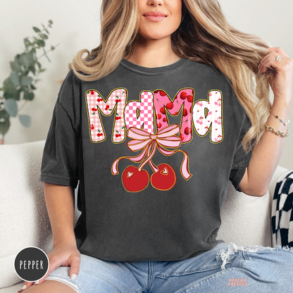 Woman wearing a pepper Comfort Colors t-shirt with a Mama cherry bow graphic in pink cherry print and coquette style.
