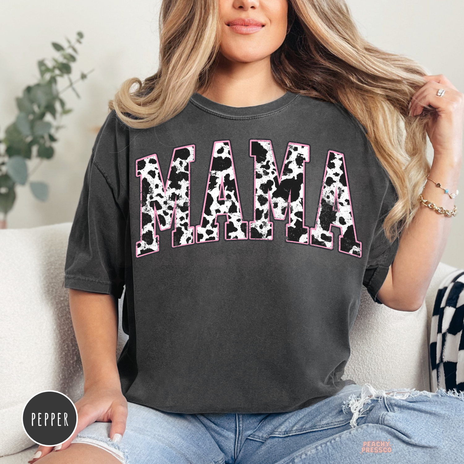 Pepper Comfort Colors garment-dyed t-shirt featuring a distressed cow print "MAMA" graphic with pink accents. Stylish western mom shirt for everyday wear.
