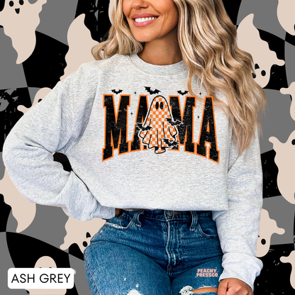 Woman wearing an ash grey crewneck sweatshirt featuring a distressed varsity Mama design with an orange checkered ghost, bats and spooky Halloween details.