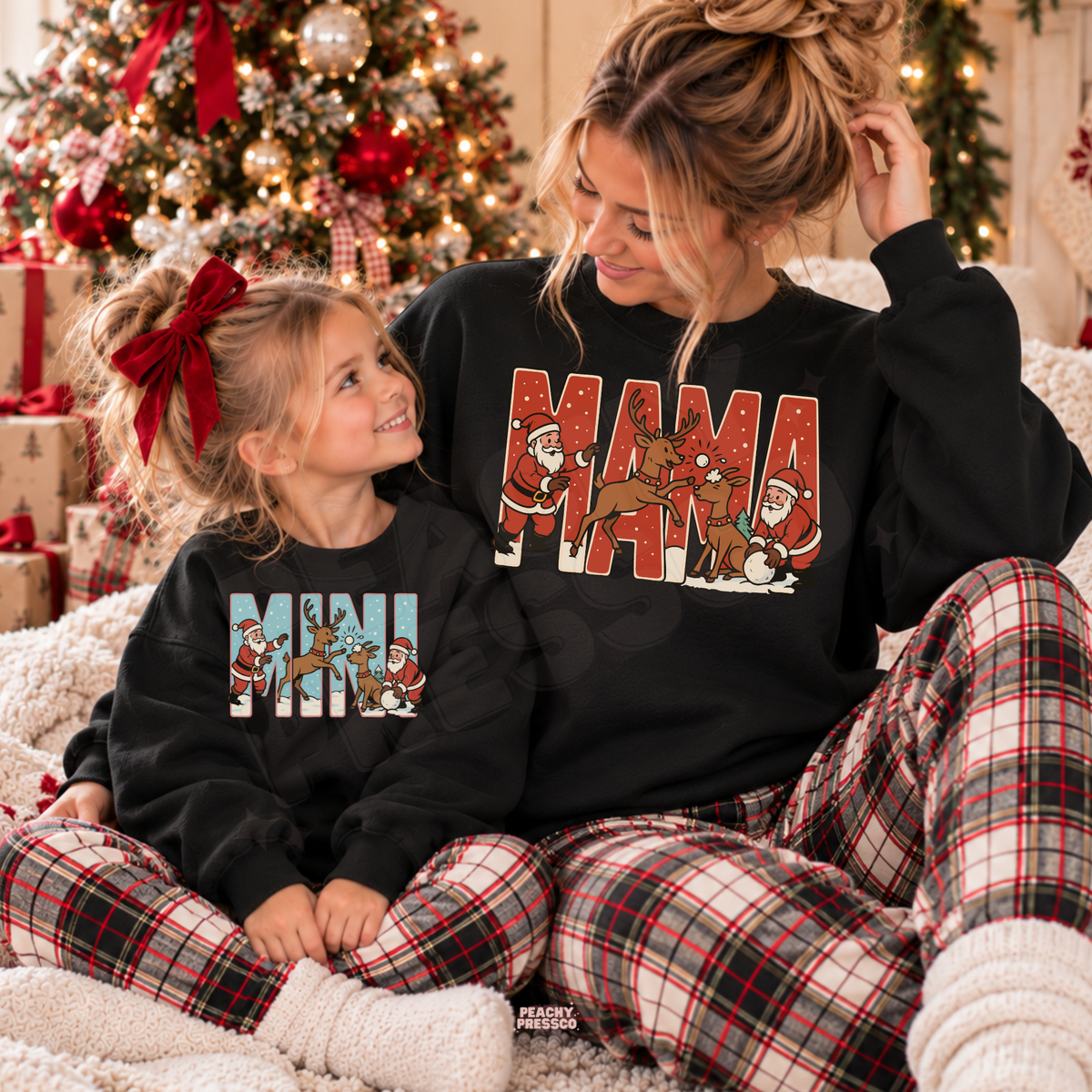 Mom and daughter wearing matching black Mama and Mini Christmas crewneck sweatshirts with vintage Santa and reindeer design.