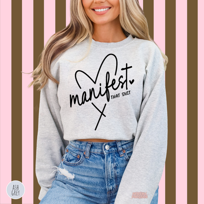 Ash grey Manifest That Shit sweatshirt featuring black cursive lettering, a heart illustration and a sassy motivational affirmation.