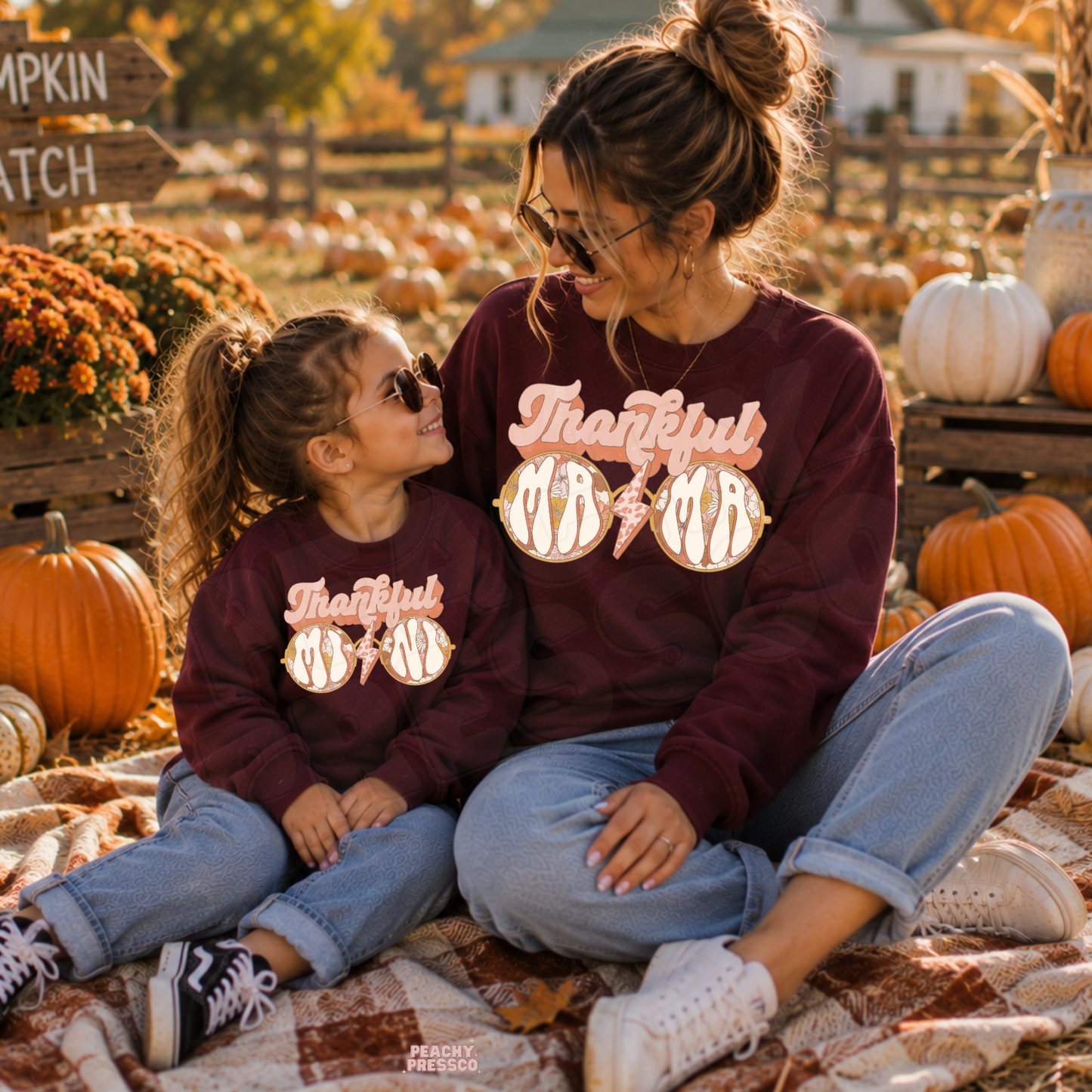 Mother and daughter in matching maroon Thankful Mama sweatshirts enjoying a fall pumpkin patch, cozy Thanksgiving family outfit.