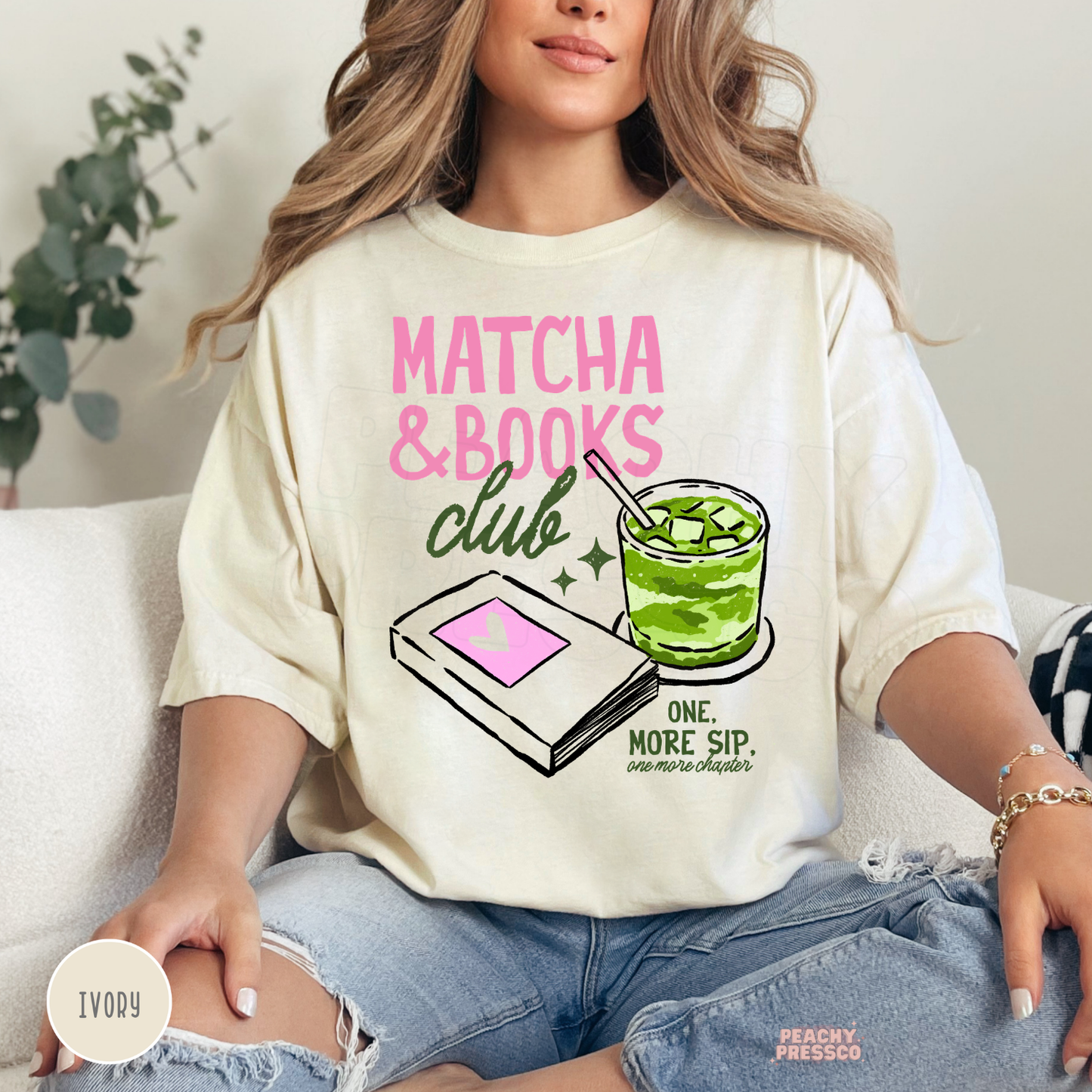 Woman wearing an ivory Comfort Colors t-shirt featuring the Matcha & Books Club graphic with an iced matcha latte, book illustration, and the phrase "One More Sip, One More Chapter." Cute oversized reading shirt for book lovers and matcha lovers.