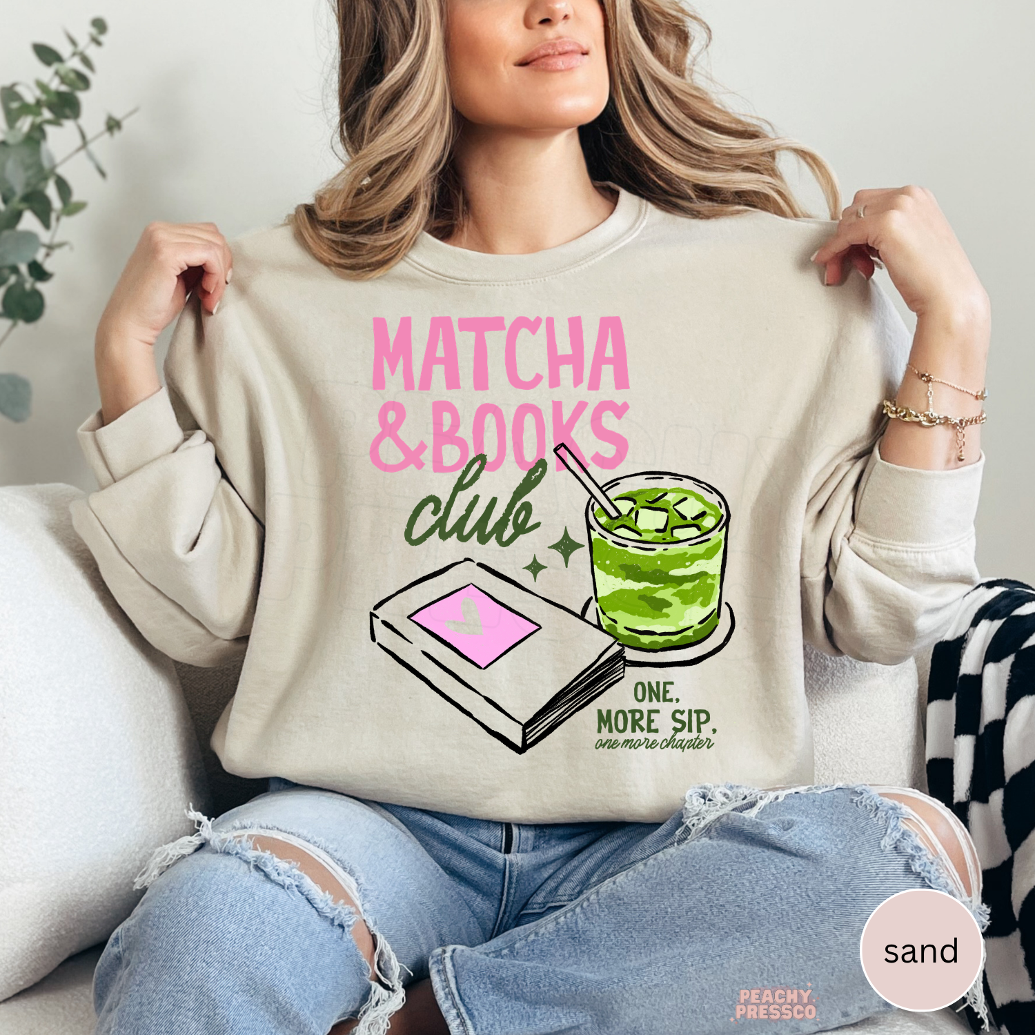 Woman wearing a sand-colored crewneck sweatshirt featuring the Matcha & Books Club graphic with a matcha latte, book illustration, and reading-inspired design. Cozy oversized sweatshirt for book lovers and matcha fans.