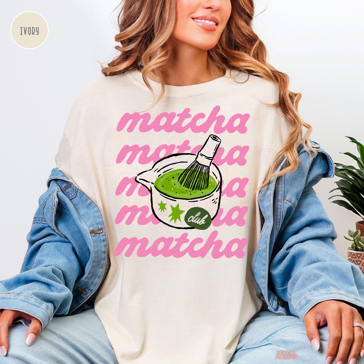 Ivory Matcha Club shirt featuring repeated pink matcha lettering, a bowl of vibrant green matcha tea, bamboo whisk, and cute Matcha Club artwork.