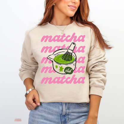 Sand Matcha Club sweatshirt featuring repeated pink matcha lettering, a green matcha tea bowl, bamboo whisk, and cute retro-inspired graphic.