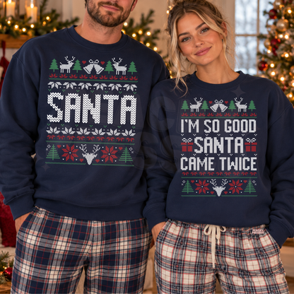 A man and a woman wearing matching navy blue Christmas sweaters with holiday graphics. The man's sweater says 'SANTA' in large white letters, and the woman's says 'I'M SO GOOD SANTA CAME TWICE'.