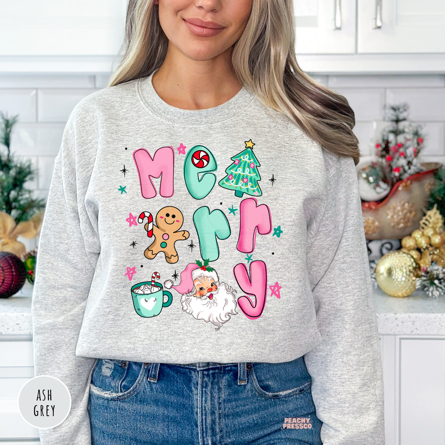 Woman wearing an ash grey Christmas crewneck featuring a colorful Merry Christmas design with Santa, gingerbread man, Christmas tree and holiday mug.
