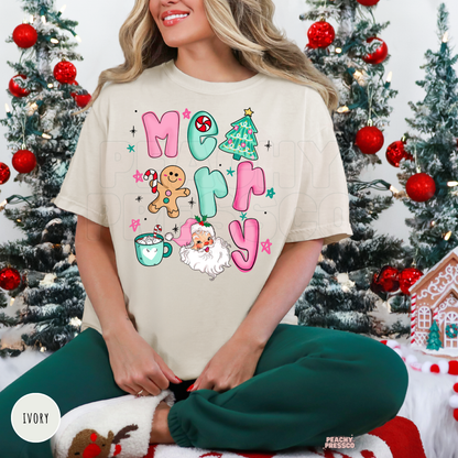Woman wearing an ivory Christmas t-shirt with a colorful Merry Christmas graphic featuring Santa, gingerbread man, Christmas tree and candy cane.
