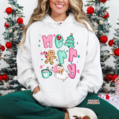Woman wearing a white Christmas hoodie featuring a colorful Merry Christmas design with Santa, gingerbread man, Christmas tree and holiday mug.