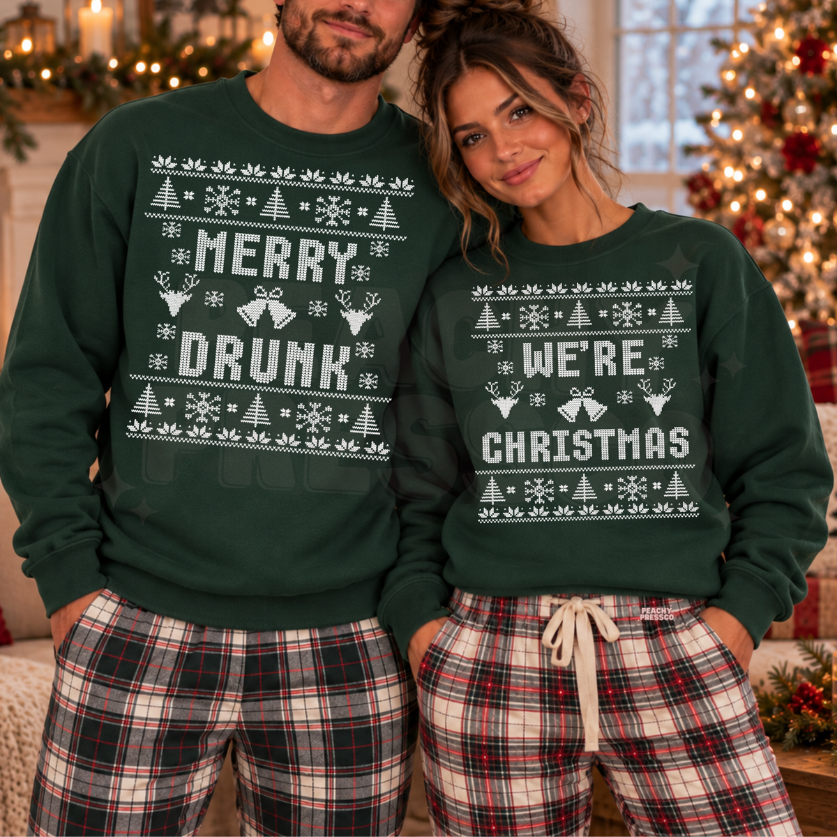 A man and a woman wearing matching dark green Christmas sweatshirts with white holiday graphics and text, paired with red and white plaid pajama pants in a decorated holiday home setting.