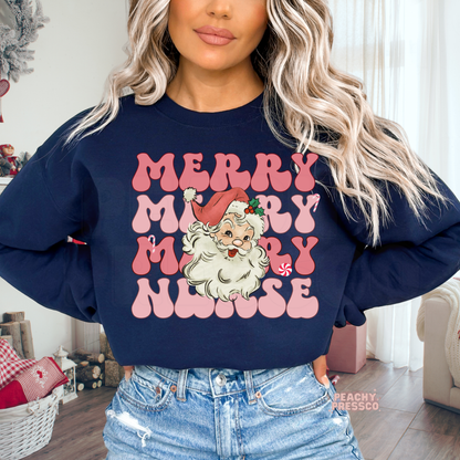 A woman wearing a navy blue crewneck sweatshirt with a pink and white graphic that reads 'MERRY MERRY MERRY NURSE' with an illustration of Santa Claus, paired with light-wash distressed denim jeans.