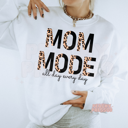 White sweatshirt featuring a bold "Mom Mode All Day Every Day" leopard print graphic. Funny minimalist mom sweatshirt for everyday wear.