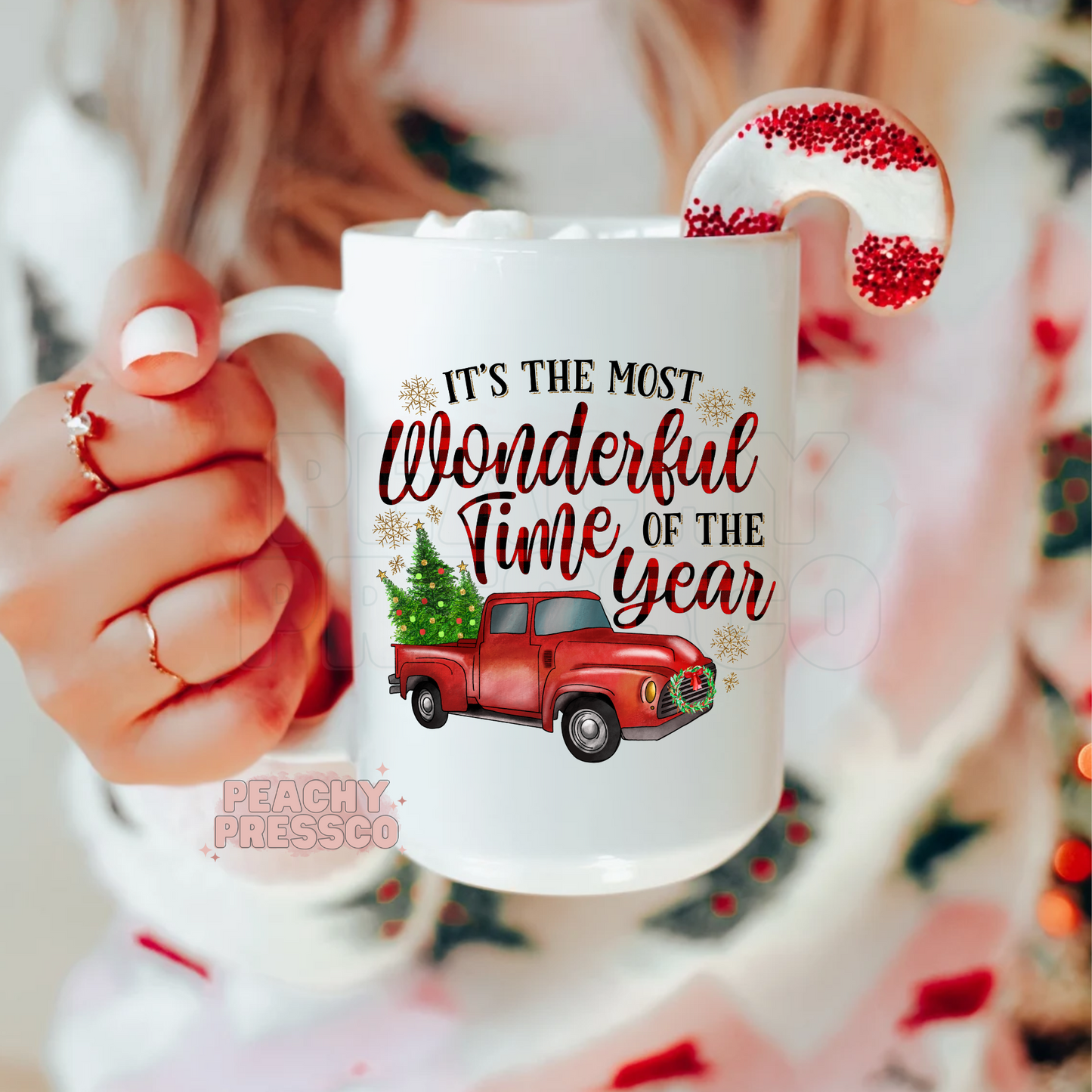 White holiday coffee mug featuring a red vintage pickup truck carrying a Christmas tree with plaid text reading Its The Most Wonderful Time Of The Year.