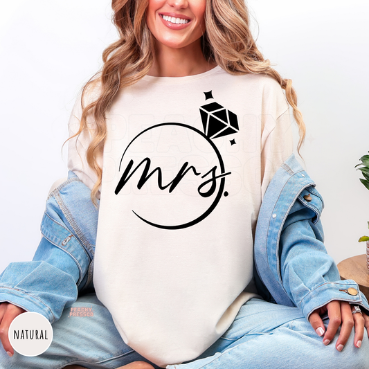 Natural colored bridal shirt featuring minimalist "Mrs." script with a diamond ring illustration. Perfect for wedding events, engagement photos, honeymoon travel, and bridal gifts.