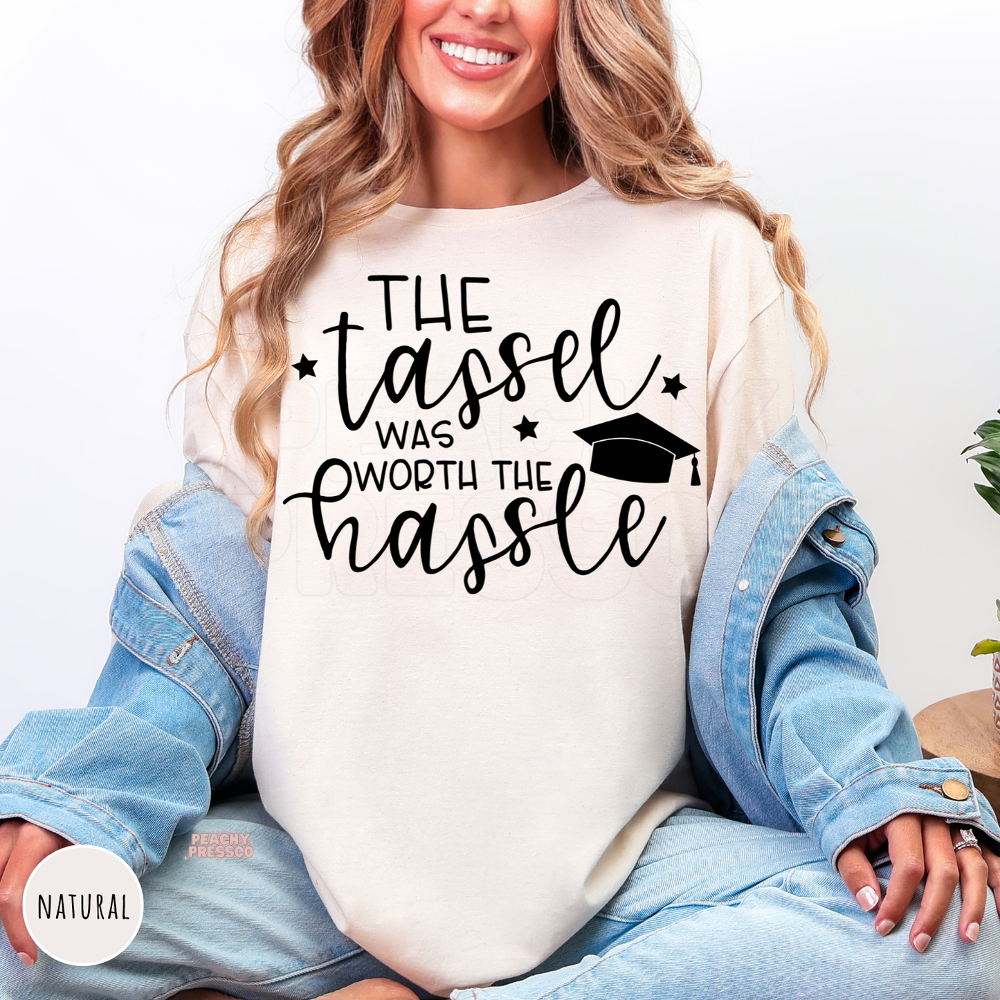 Natural cream graduation t-shirt with "The Tassel Was Worth the Hassle" quote and graduation cap graphic. Unisex graduation shirt perfect for senior gifts and commencement day.