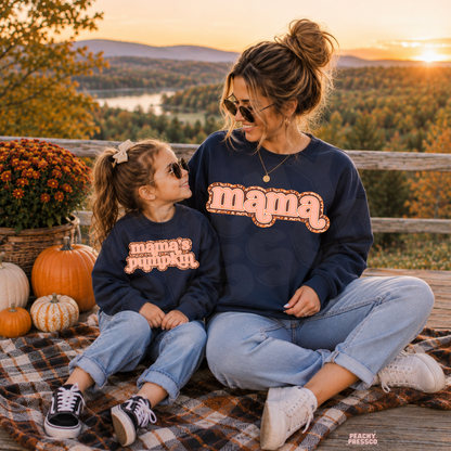 Mama and mini wearing matching navy blue fall sweatshirts with "Mama" and "Mama's Pumpkin" graphics overlooking a scenic autumn landscape.