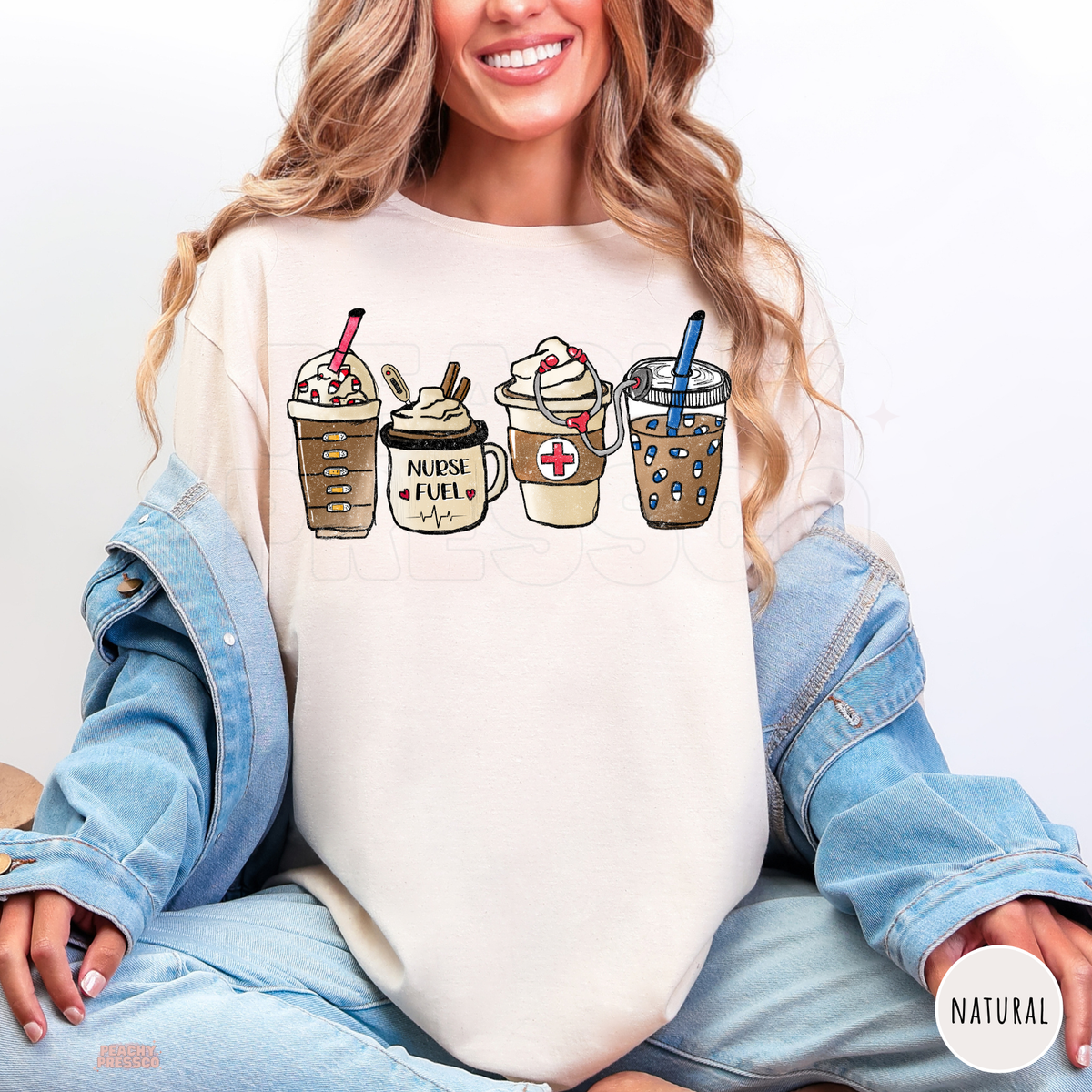 Natural Nurse Fuel shirt with four illustrated coffee drinks, a Nurse Fuel mug, medical cross and stethoscope, styled with a denim jacket and jeans.