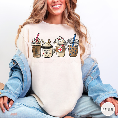 Natural Nurse Fuel shirt with four illustrated coffee drinks, a Nurse Fuel mug, medical cross and stethoscope, styled with a denim jacket and jeans.