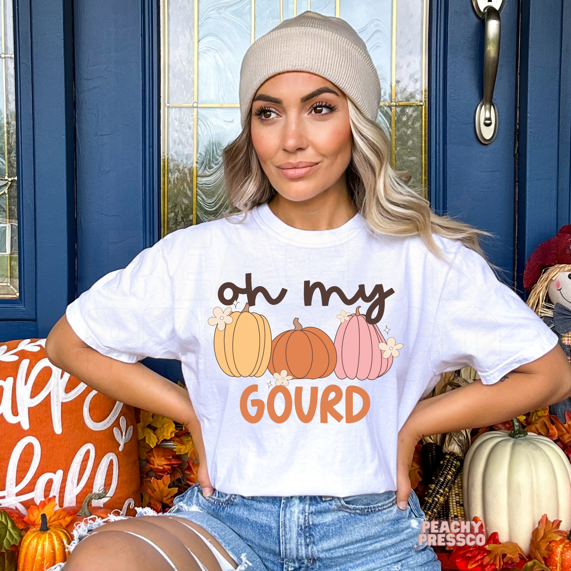 Woman wearing a white t-shirt with a cute "Oh My Gourd" fall pumpkin graphic, perfect for autumn and Thanksgiving outfits.