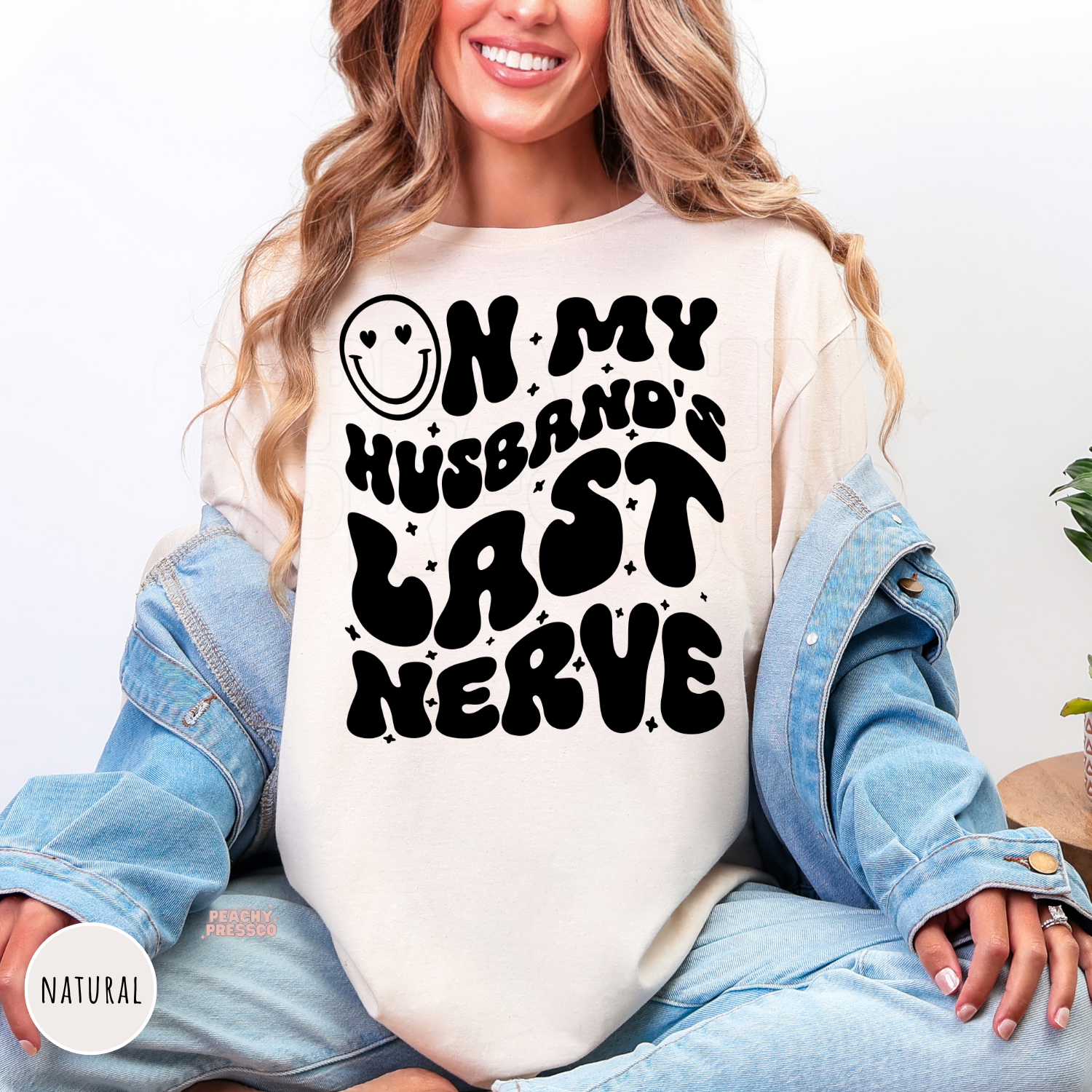 Natural shirt featuring a bold "On My Husband's Last Nerve" retro graphic with playful smiley face artwork. Stylish sweatshirt for wives with a sense of humor.