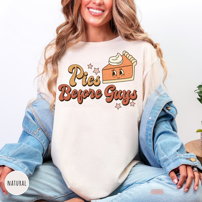 Woman wearing a natural t-shirt featuring a trendy "Pies Before Guys" pumpkin pie graphic in retro fall colors.