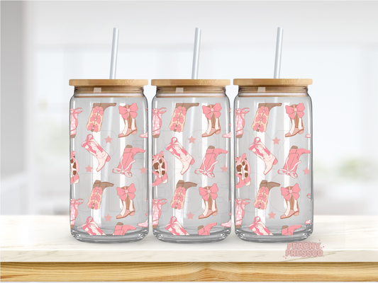 16oz glass cup decorated with pink cowgirl boots, bows, stars, and western-inspired illustrations. Includes bamboo lid and reusable glass straw.
