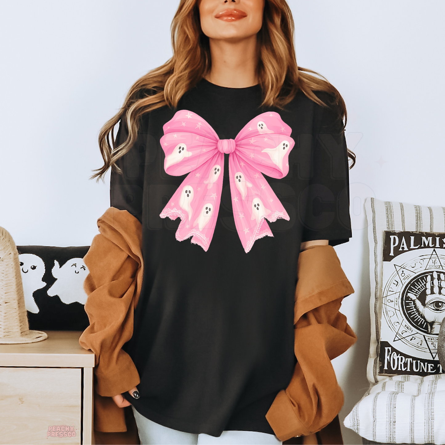 Black Halloween T-shirt featuring an oversized pink bow with cute white ghosts and stars for a girly spooky look