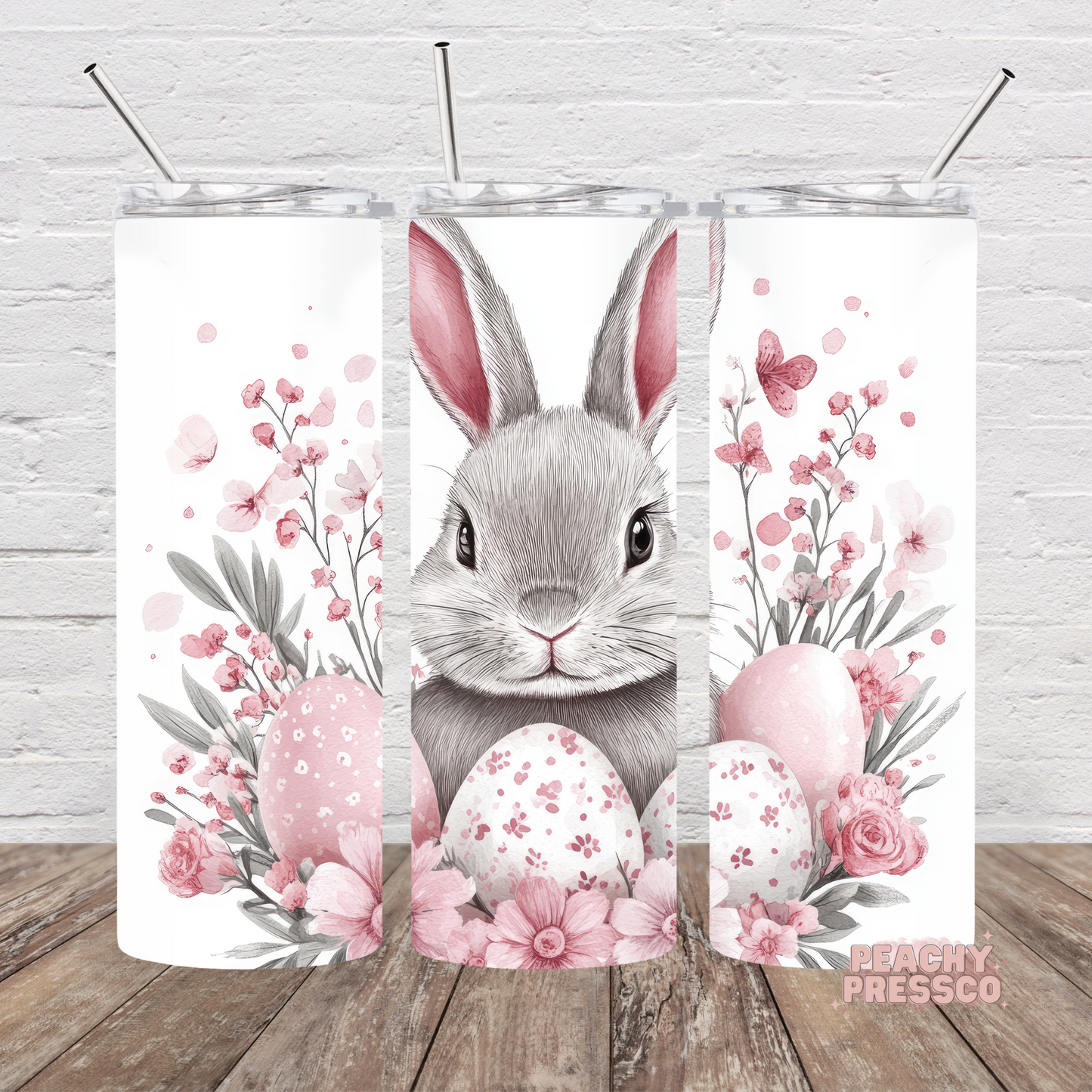 Watercolor Easter bunny skinny tumbler with pink flowers, pastel Easter eggs, butterflies, and soft spring floral artwork.