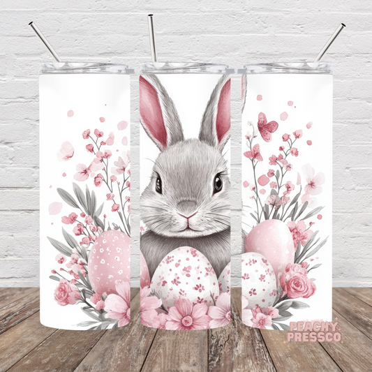 Watercolor Easter bunny skinny tumbler with pink flowers, pastel Easter eggs, butterflies, and soft spring floral artwork.
