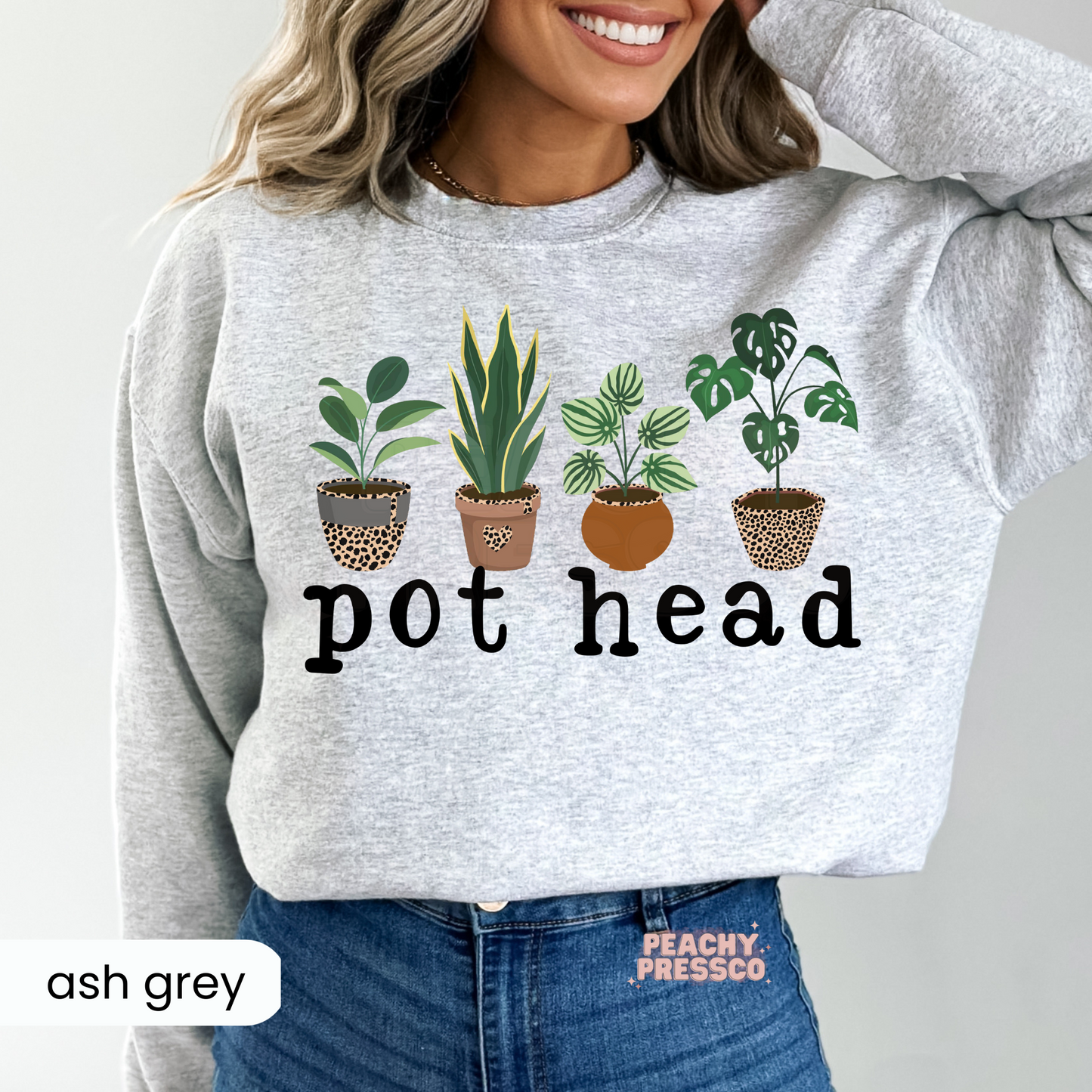 Ash grey crewneck sweatshirt featuring a funny "Pot Head" houseplant graphic with leafy green plants in patterned pots. Soft botanical sweatshirt for plant enthusiasts and gardening fans.