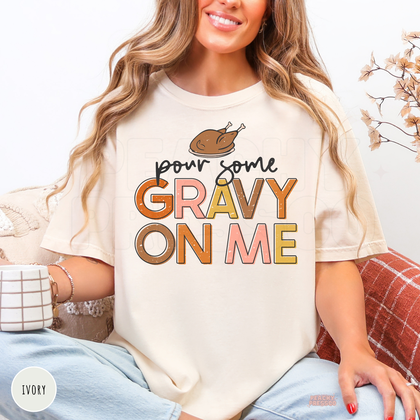 Woman wearing an ivory Comfort Colors t-shirt with a funny "Pour Some Gravy On Me" Thanksgiving graphic in retro fall colors.