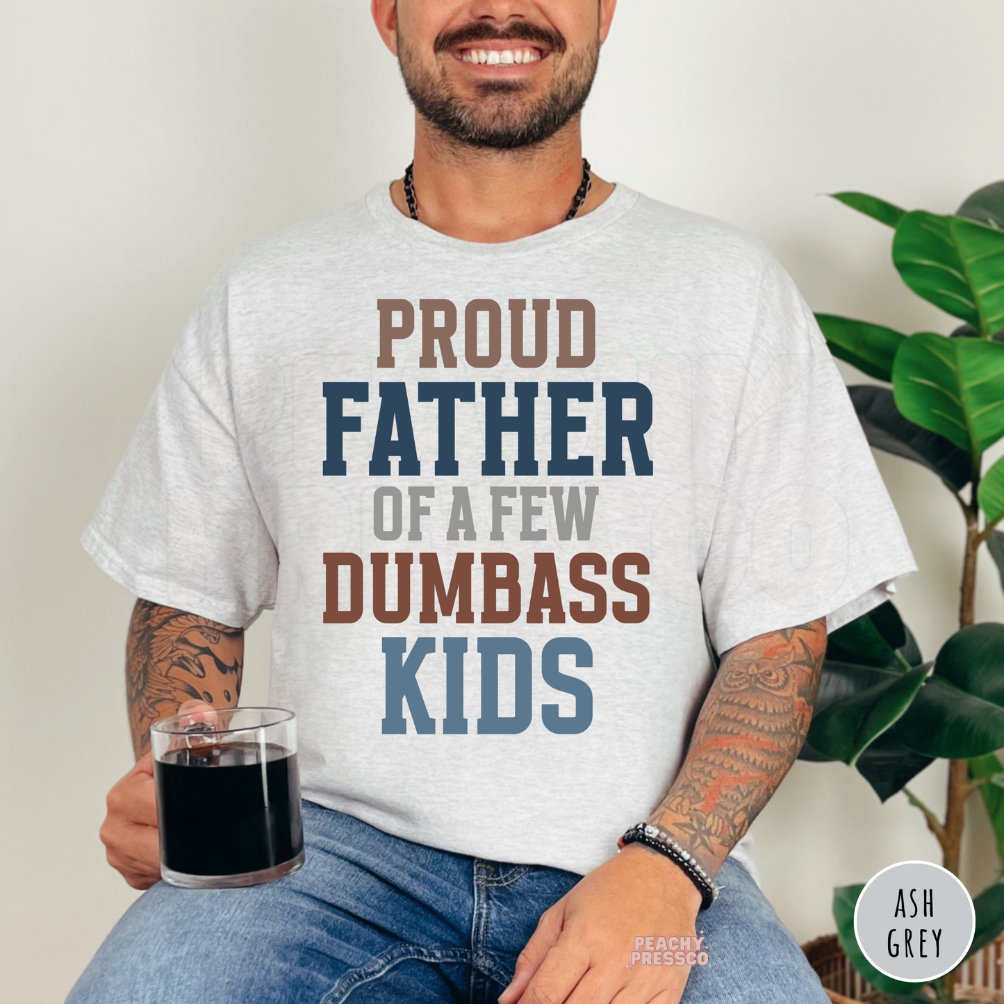 Ash grey unisex t-shirt featuring a colorful "Proud Father of a Few Dumbass Kids" graphic, funny gift for fathers.