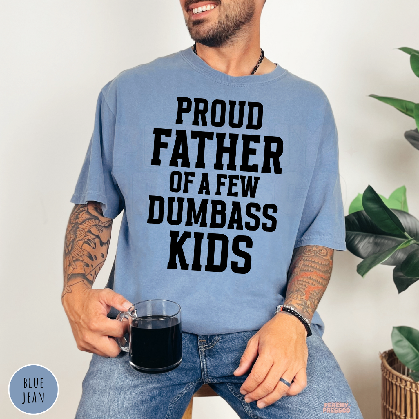 Blue Jean Comfort Colors men's t-shirt with "Proud Father of a Few Dumbass Kids" graphic, funny dad apparel gift idea.