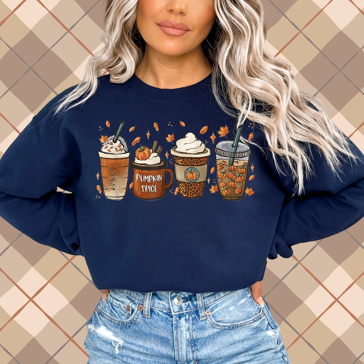 Woman wearing a navy crewneck sweatshirt featuring a pumpkin spice latte coffee graphic with fall drinks and autumn leaves.