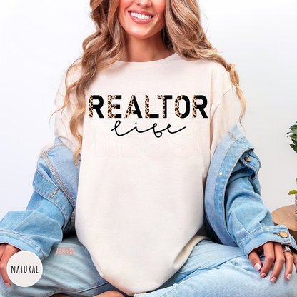 Woman wearing a natural shirt featuring a stylish Realtor Life leopard print graphic, perfect for real estate agents and brokers.