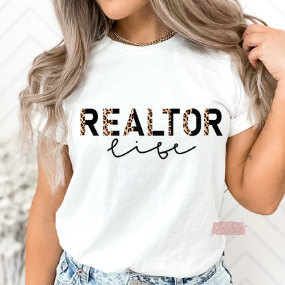 White graphic t-shirt featuring a Realtor Life leopard print design, ideal for real estate professionals, brokers, and property agents.